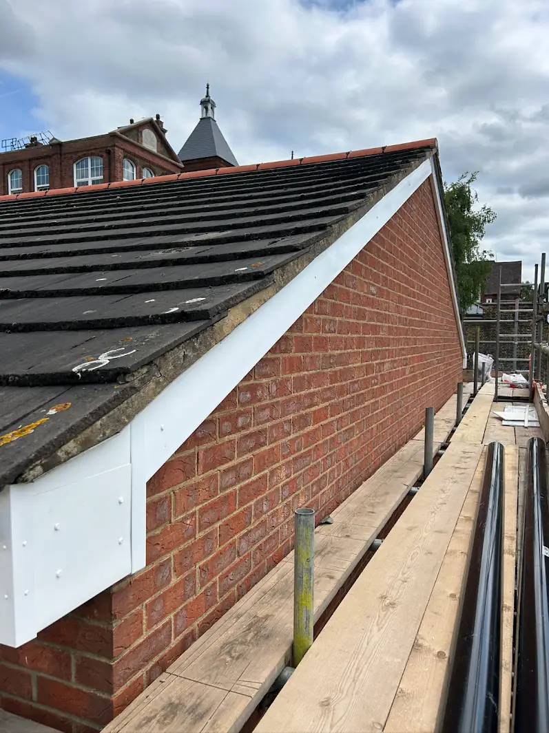 Roof repair or replacement: pitched tiled roof on a house in Surrey being assessed by Hills Roofing